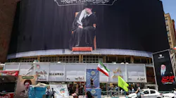 An Iranian woman waves a national flag under a billboard depicting slain supreme leader Ayatollah Ali Khamenei at Valiasr Square in Tehran on June 15, 2026. The United States and Iran agreed a peace deal and an 'immediate and permanent' end to military operations on all fronts including Lebanon, mediator Pakistan said, signaling the apparent end to more than three months of war in Middle East.