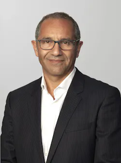 A man wearing a suit smiling at the camera A man wearing a suit smiling at the camera