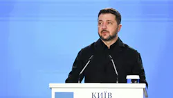 A man standing at a podium speaking into a microphone A man standing at a podium speaking into a microphone