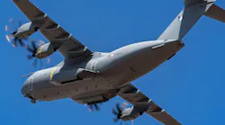 A gray military aircraft flying in front of a blue sky