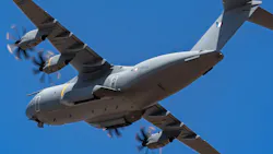 A gray military aircraft flying in front of a blue sky A gray military aircraft flying in front of a blue sky