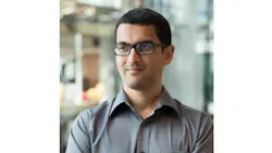 A close-up photograph of a man wearing a polo shirt smiling while looking off in the distance A close-up photograph of a man wearing a polo shirt smiling while looking off in the distance