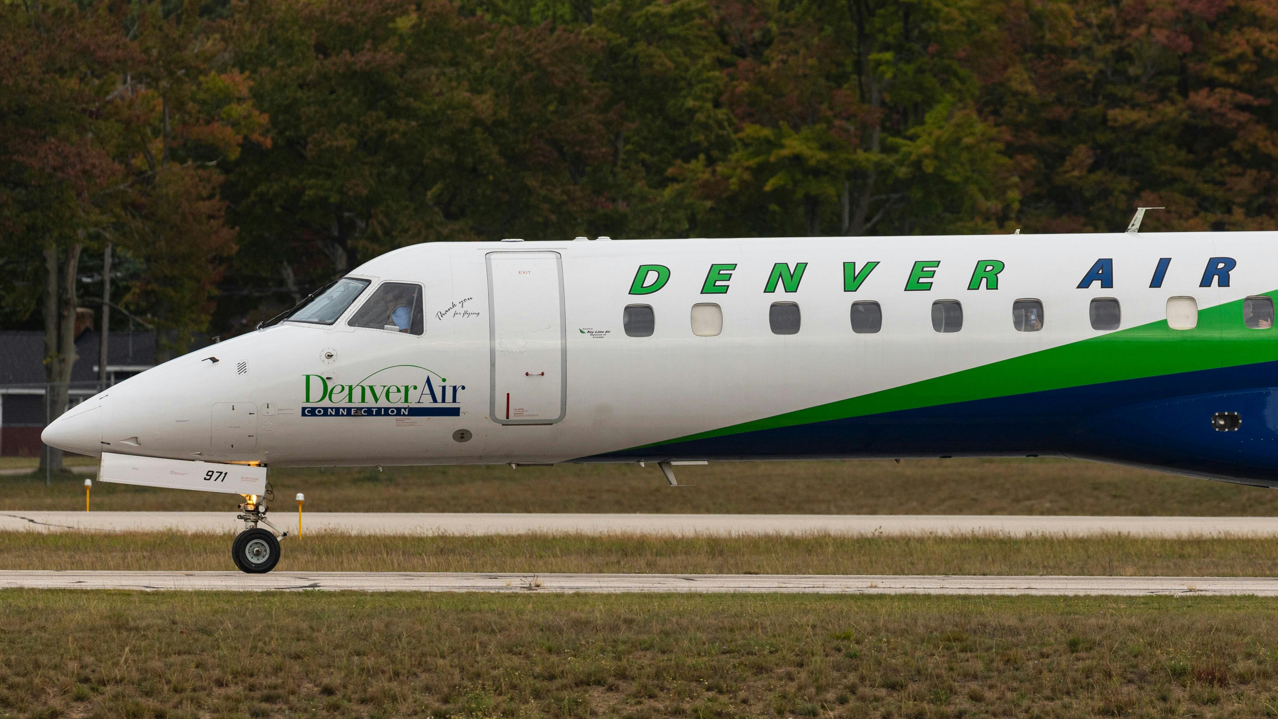 A white airplane with green accents on it and text that reads: DENVER AIR
