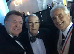 Three men wearing suits smiling at a camera while taking a selfie Three men wearing suits smiling at a camera while taking a selfie