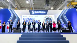 A line of people wearing business attire cutting a large ribbon in front of a backdrop that reads: SAFRAN Grand Opening