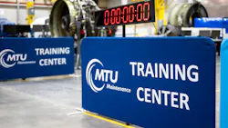 Two signs that read, 'MTU Maintenance Training Center' standing near a clock set at 00:00