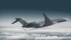 A gray airplane flying over a blanket of clouds in a dark sky