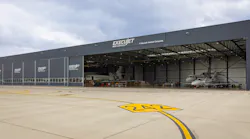 An outdoor photograph of a warehouse-type building with a sign on the front that says 'ExecuJet MRO Services'