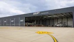 An outdoor photograph of a warehouse-type building with a sign on the front that says 'ExecuJet MRO Services'