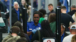 A TSA agent checks a passenger's identification in a security line at O'Hare International Airport, April 14, 2026, in Chicago.