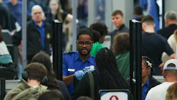 A TSA agent checks a passenger's identification in a security line at O'Hare International Airport, April 14, 2026, in Chicago.