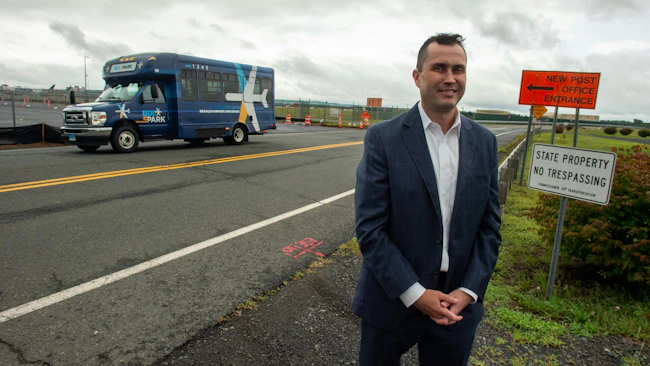 Michael Shea, Connecticut Airport Authority executive director and CEO, discusses the new Lot 3 parking area as a BDL sPARK shuttle bus passes by at Bradley International Airport.