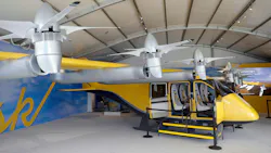 A small yellow aircraft with several propellers (an electric air-taxi)