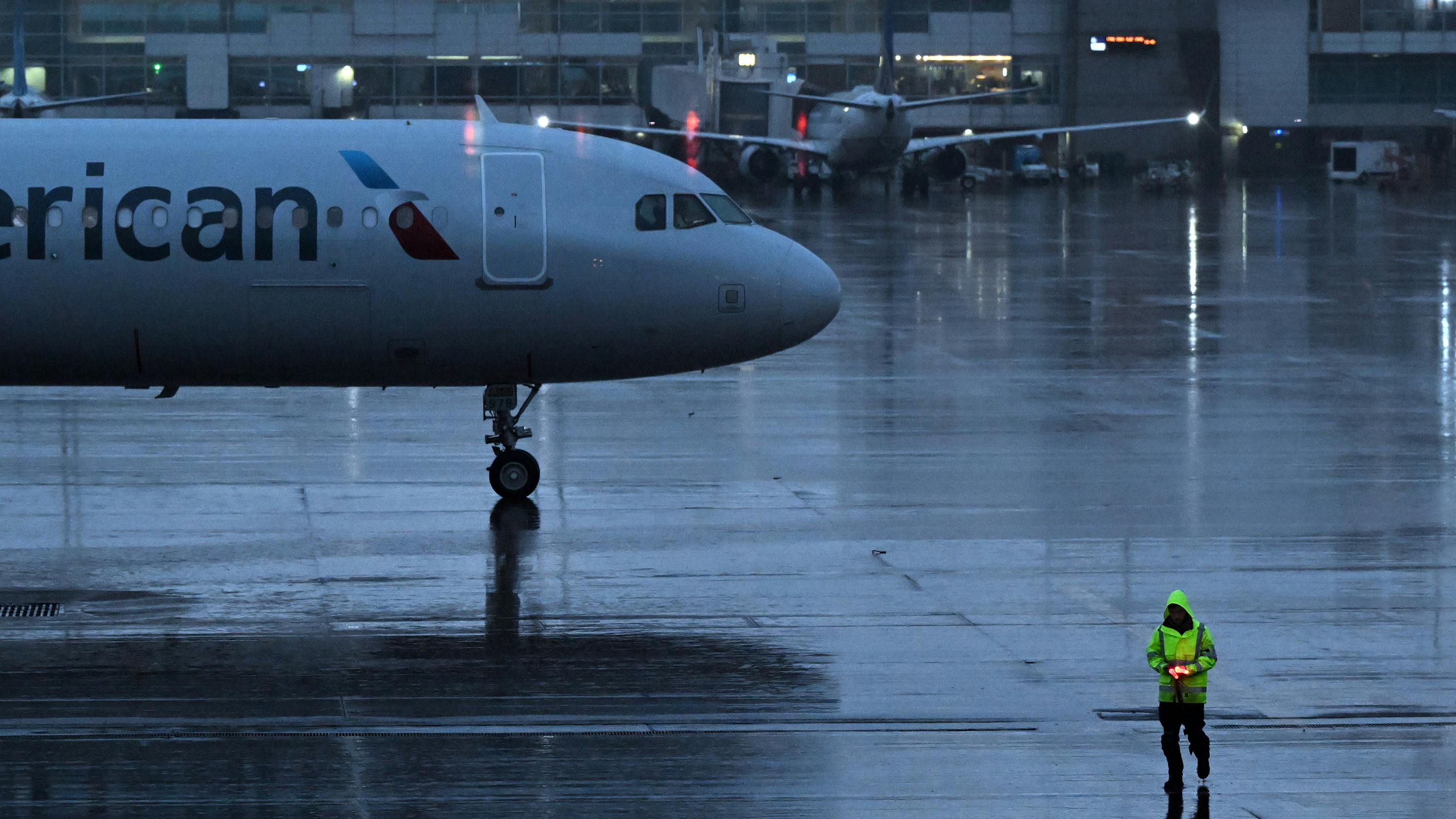Ground crew work as the rain begins to fall in anticipation of the upcoming snow storm at Denver International Airport in Denver on March 13, 2024.