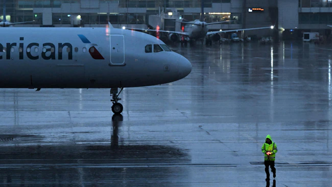 Ground crew work as the rain begins to fall in anticipation of the upcoming snow storm at Denver International Airport in Denver on March 13, 2024.