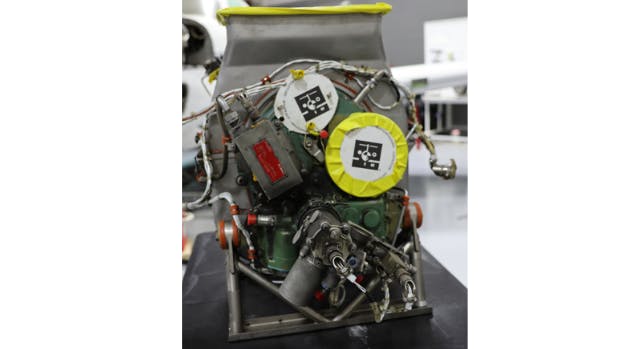 A photograph of an auxiliary power unit with metal wiring and yellow accents