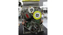 A photograph of an auxiliary power unit with metal wiring and yellow accents