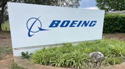 A white sign with a blue graphic and text that reads: BOEING