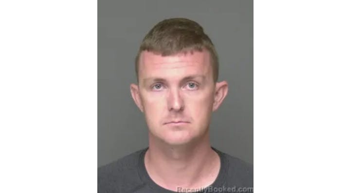 A mug shot showing a man frowning