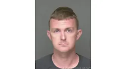 A mug shot showing a man frowning