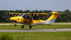 A small yellow aircraft with 'ELECTRA' printed on the side flying near the ground on a runway
