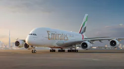 A large airplane parked on a tarmac with red and green accents on the tail and text that reads 'Emirates'