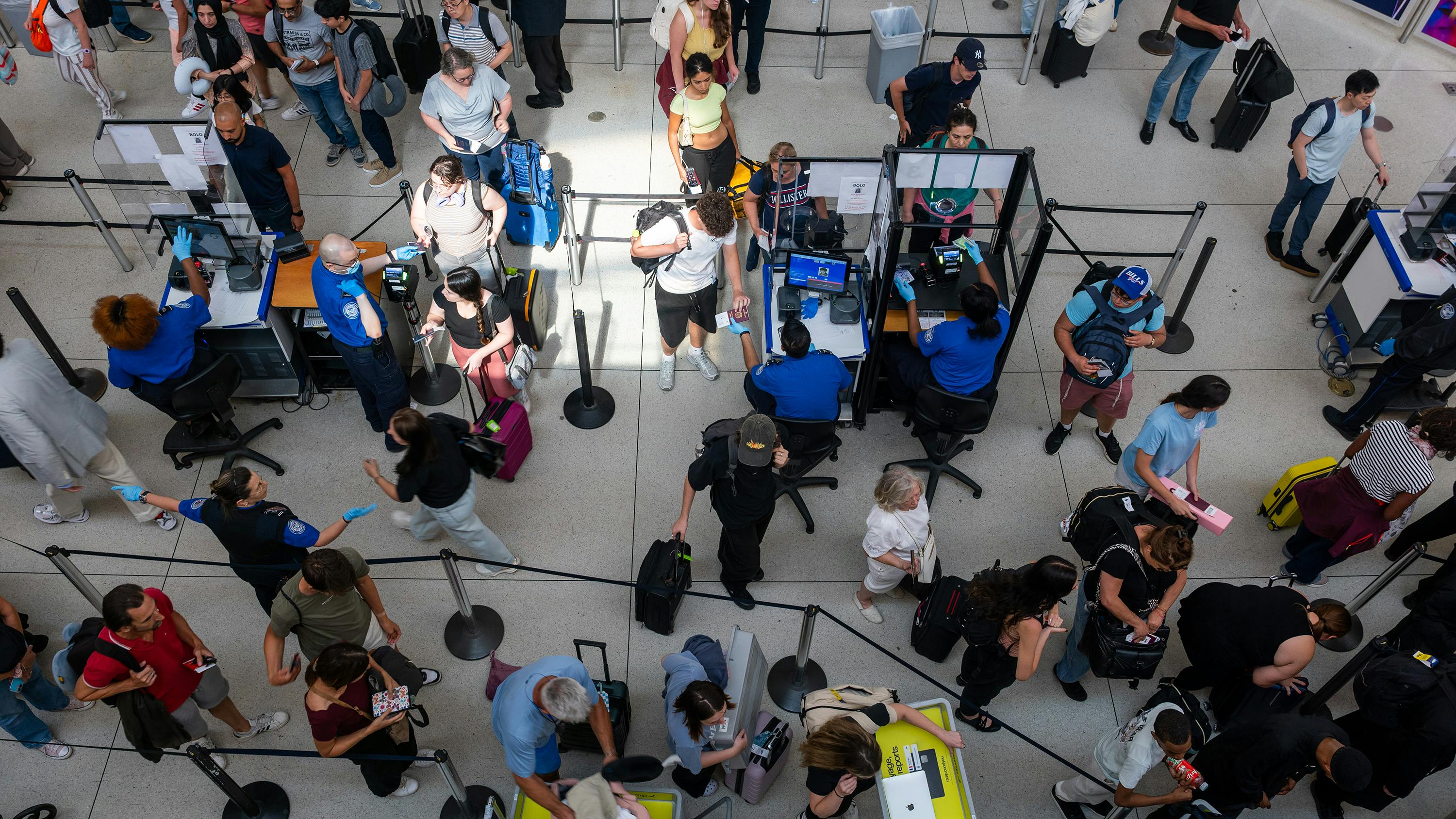 People wait in a security line at John F. Kennedy International Airport on Aug. 12, 2026, in the Queens borough of New York City.
