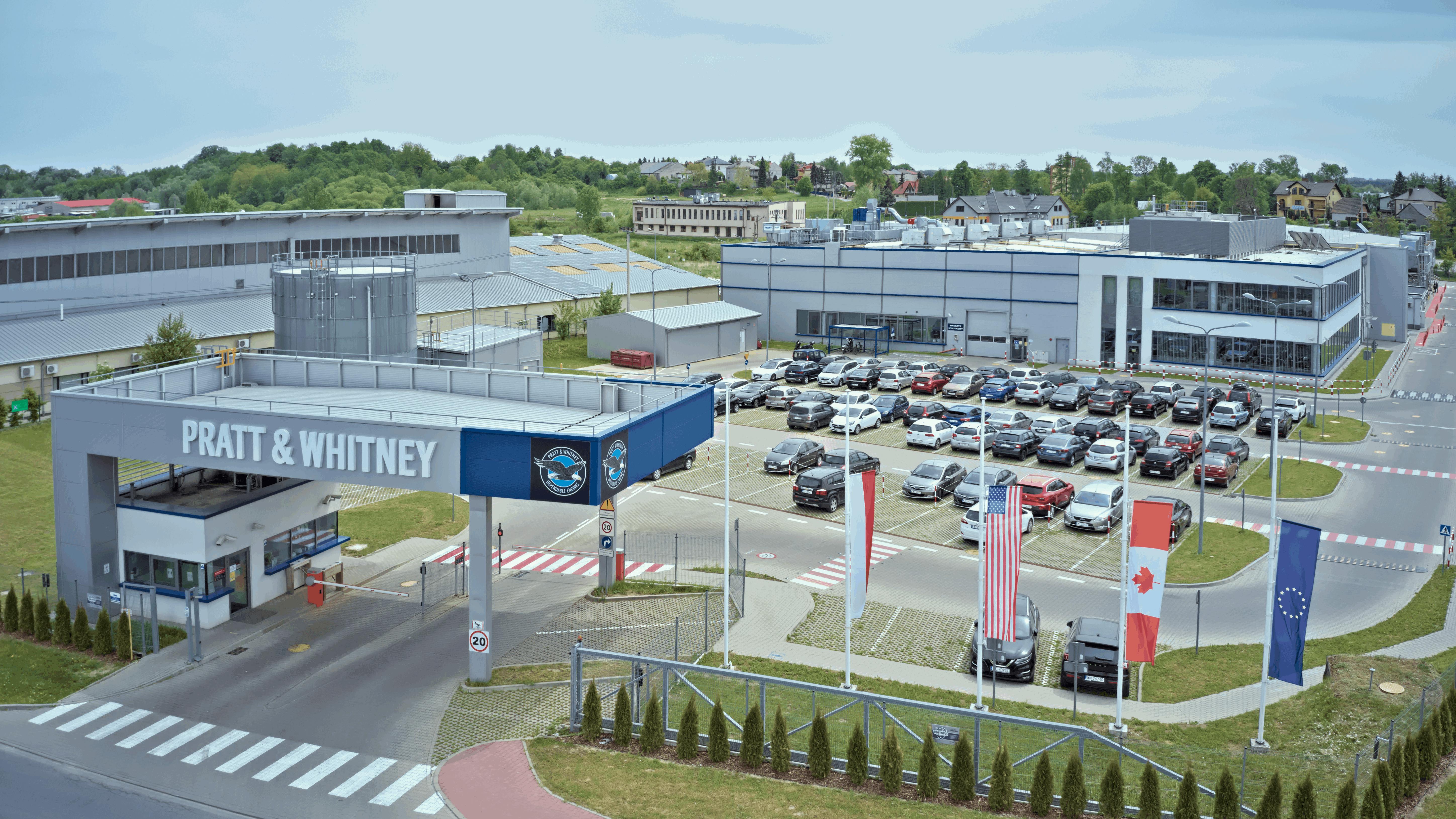 A rendering of a facility campus with a large building, parking lot and security check-in with a sign that reads: PRATT &amp; WHITNEY