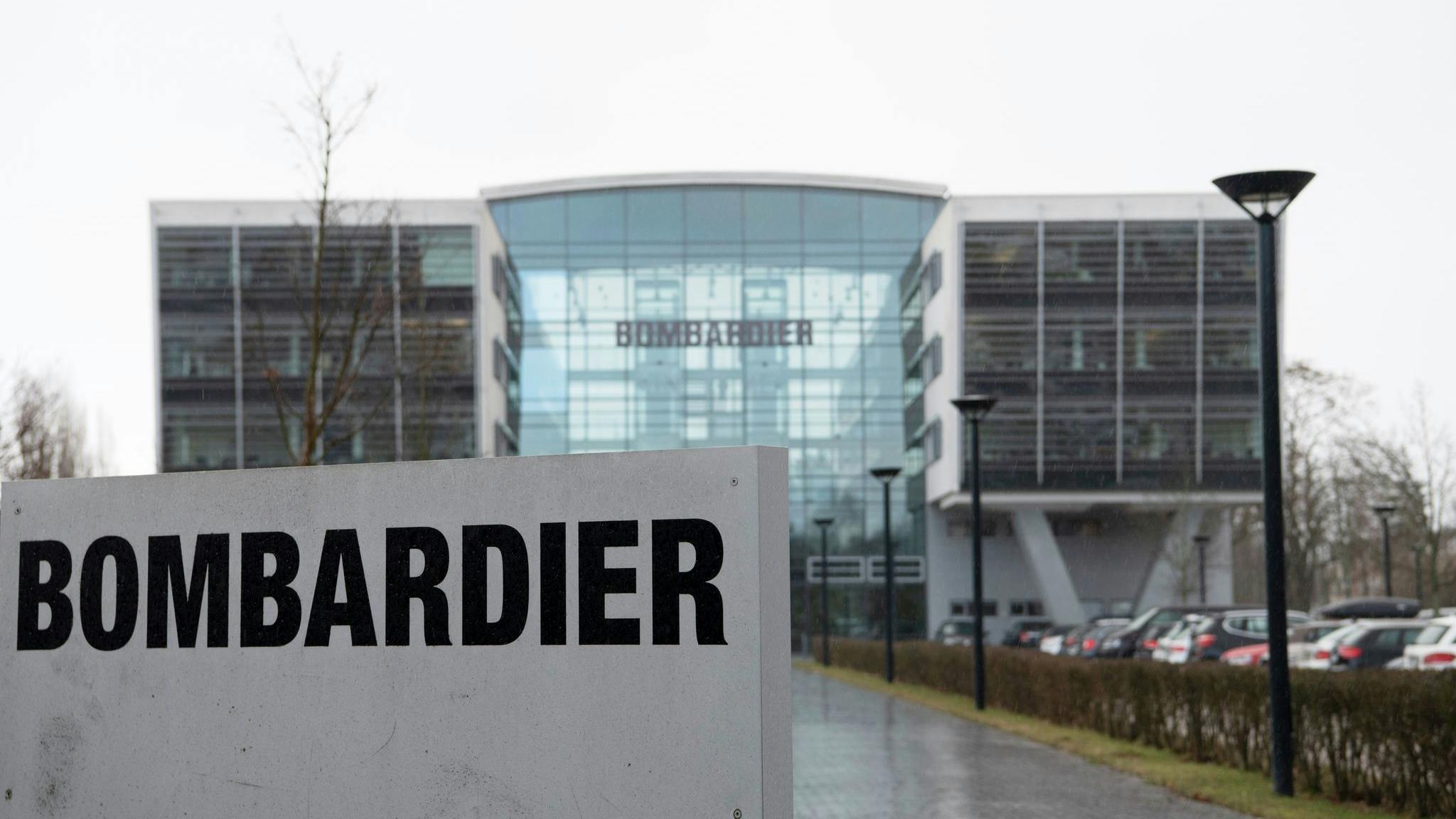 The exterior of a large glass building with a sign in front of it that reads: BOMBARDIER