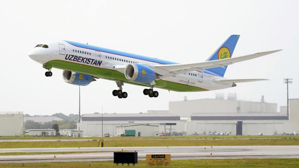 A white and blue airplane with text on the side that reads: UZBEKISTAN
