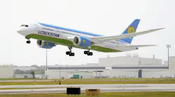 A white and blue airplane with text on the side that reads: UZBEKISTAN