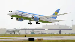 A white and blue airplane with text on the side that reads: UZBEKISTAN