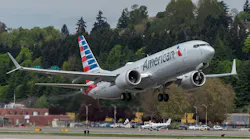 A white airplane with a red-and-blue tail text on the side that reads: American