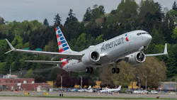 A white airplane with a red-and-blue tail text on the side that reads: American