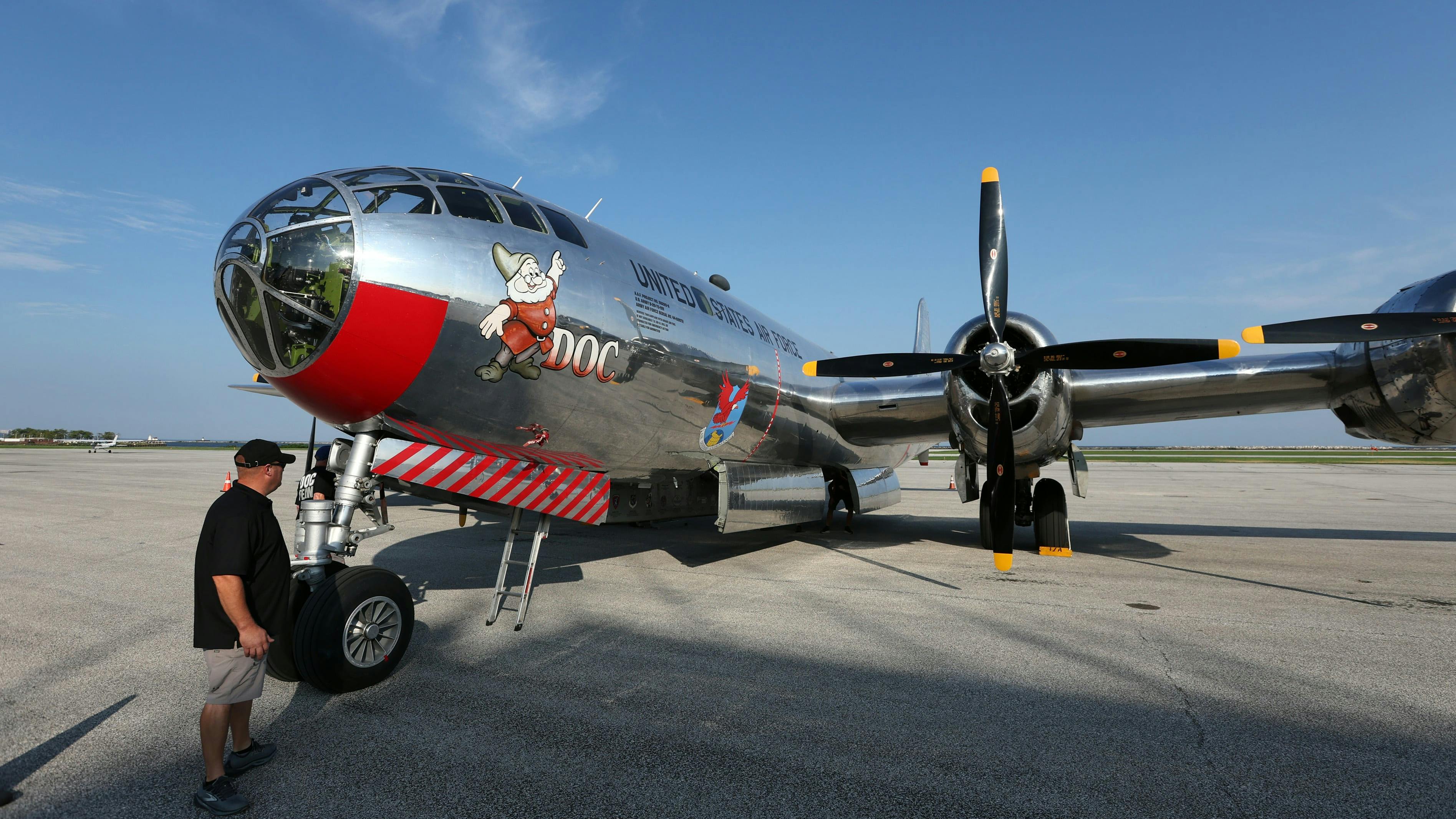 A vintage military plane with chrome-like livery and an illustration of a dwarf, with text that reads: DOC