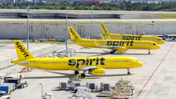 A line of yellow airplanes with 'SPIRIT' printed on the side parked at an airport