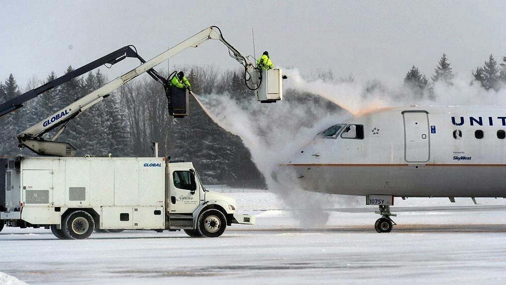 A crew sprays deicing fluid on a United Airlines plane at Syracuse Hancock International Airport in 2017.