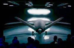 A futuristic aircraft with sharply angled wings parked in a dark hangar