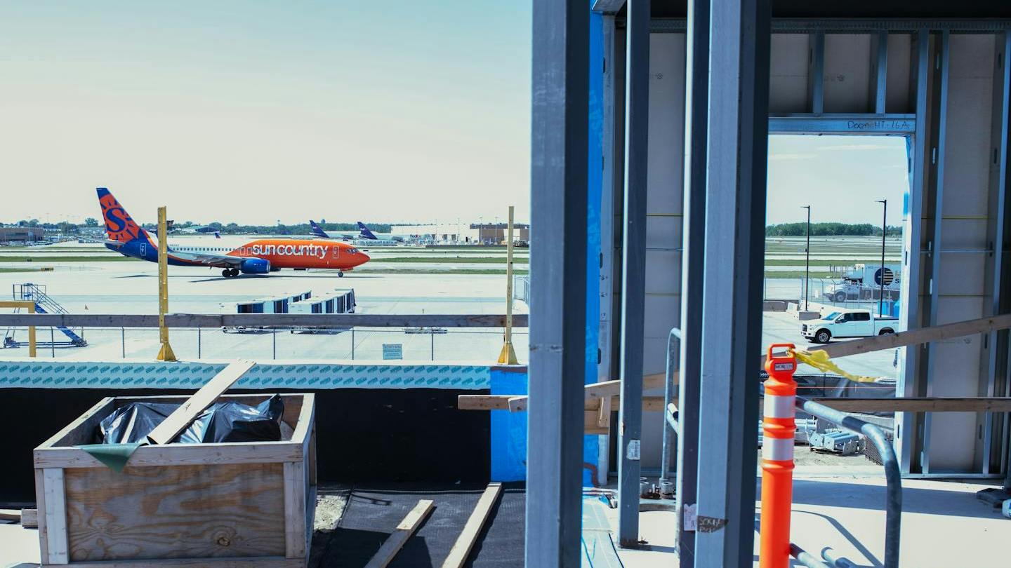 A Sun Country Airlines passenger jet taxis past the under-construction portion of Terminal 2 at Minneapolis-St. Paul International Airport in May.
