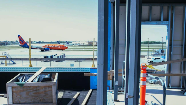 A Sun Country Airlines passenger jet taxis past the under-construction portion of Terminal 2 at Minneapolis-St. Paul International Airport in May.