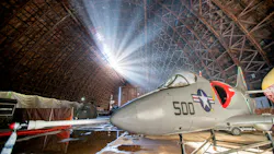 A historic plane with '500' written on the side parked inside a large hangar