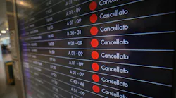 A monitor shows cancelled flights at Bologna Marconi airport.