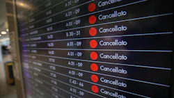 A monitor shows cancelled flights at Bologna Marconi airport.