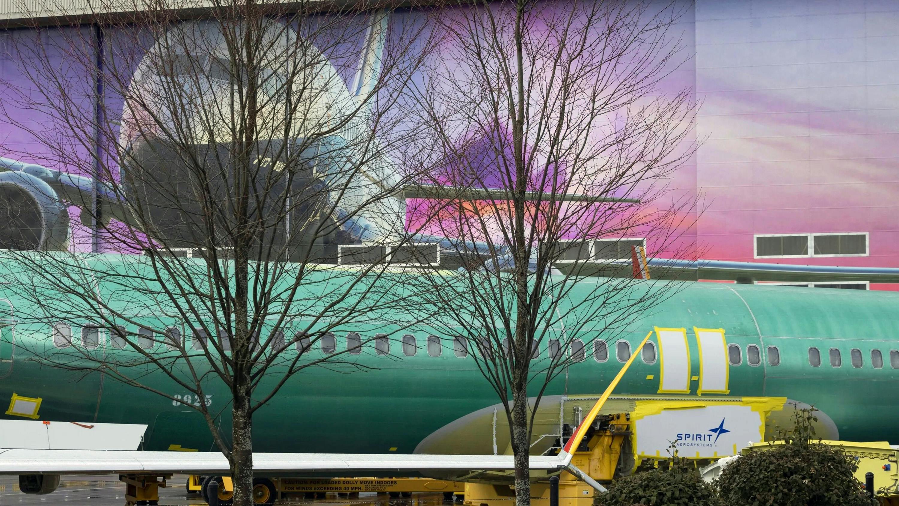 A MAX fuselage with a Spirit AeroSystems logo sits on a train at the Boeing factory in Renton, Washington, on Friday, March 1, 2024.